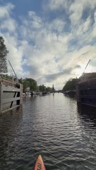 A serene kayaking scene on a cloudy afternoon in a canal